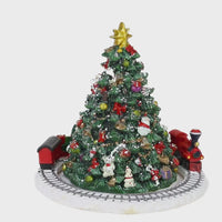 Eisenbahn fährt zur Spieluhrmelodie O Tannenbaum um den Weihnachtsbaum